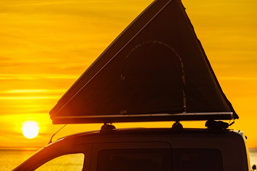 Une tente de toit de voiture est installée sur le toit dune voiture noire.