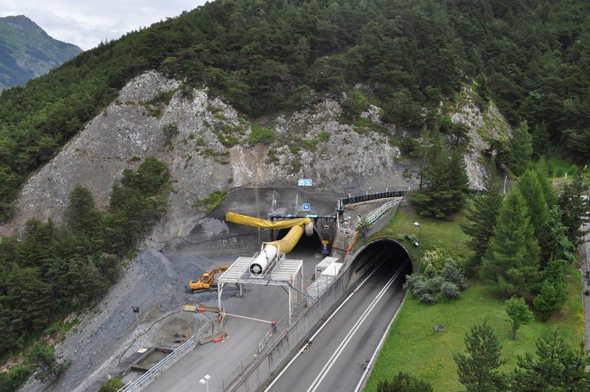 Une image aérienne dun tunnel routier en construction dans une montagne.