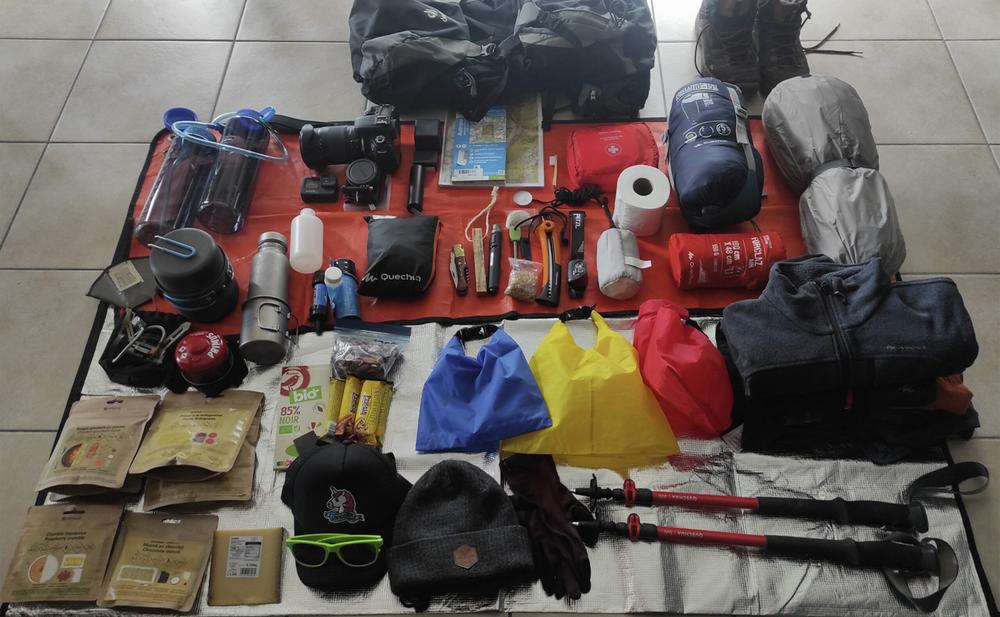 Une image montrant léquipement dun randonneur, incluant un sac à dos, une tente, un matelas de sol, des vêtements, de la nourriture et des accessoires.