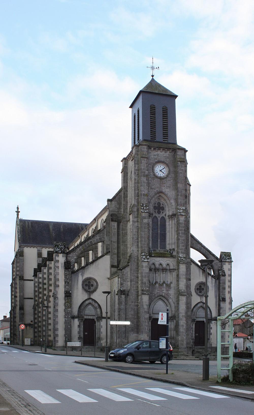 Une église en pierre avec une tour et une horloge.