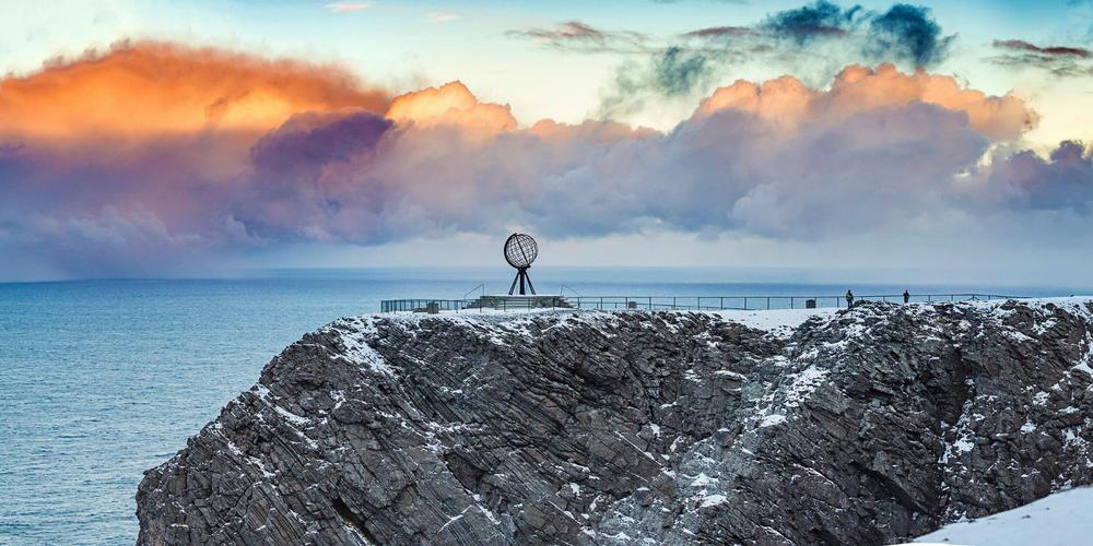Une vue du Cap Nord en Norvège, avec un globe terrestre en acier inoxydable.