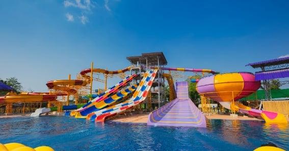 Une image dun parc aquatique avec des toboggans colorés et une piscine.