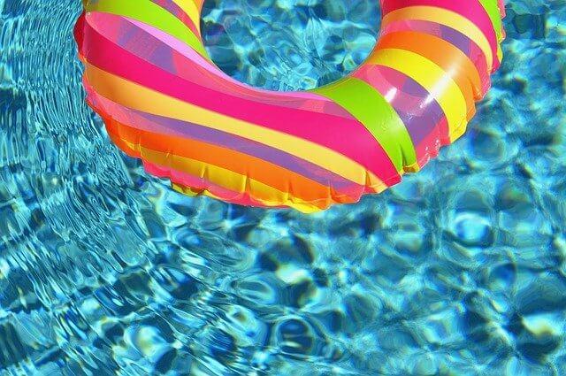 Une bouée gonflable multicolore flotte dans une piscine.