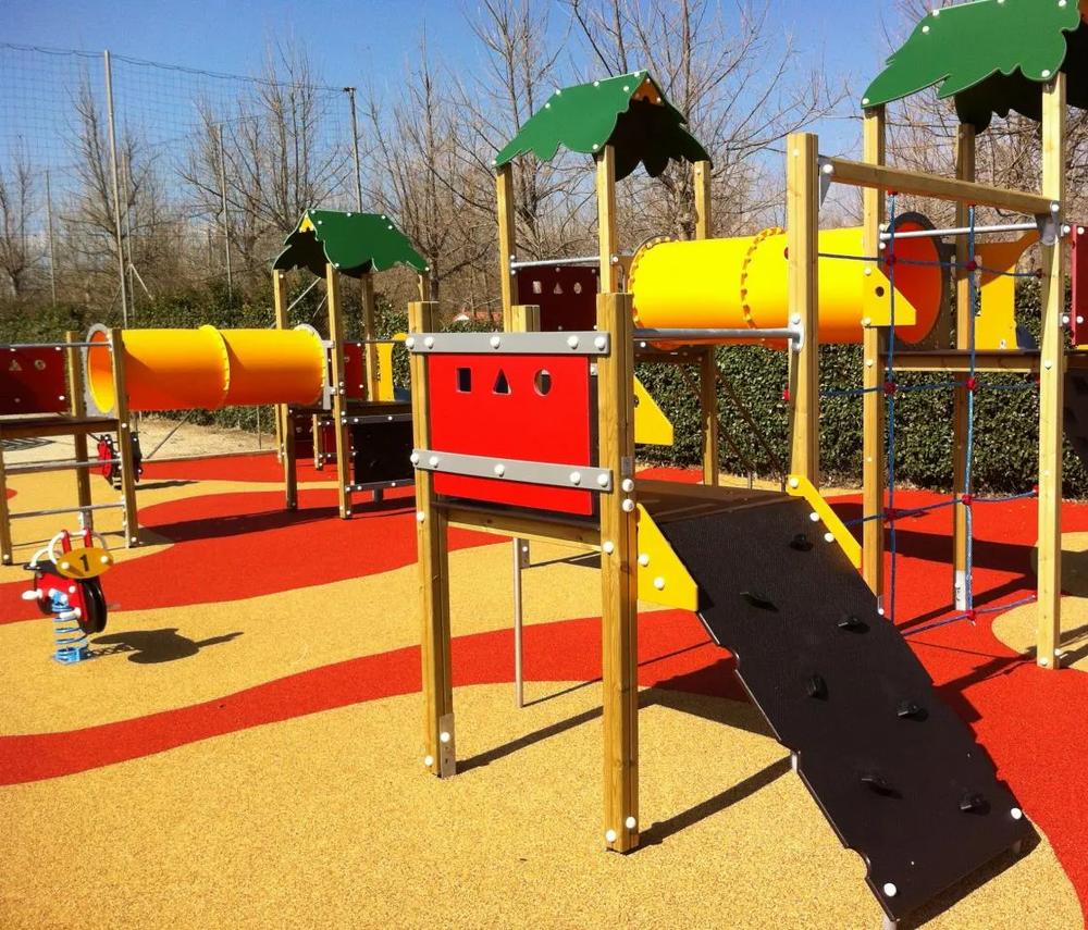 Une aire de jeux pour enfants avec un toboggan, des tunnels et des structures à grimper.