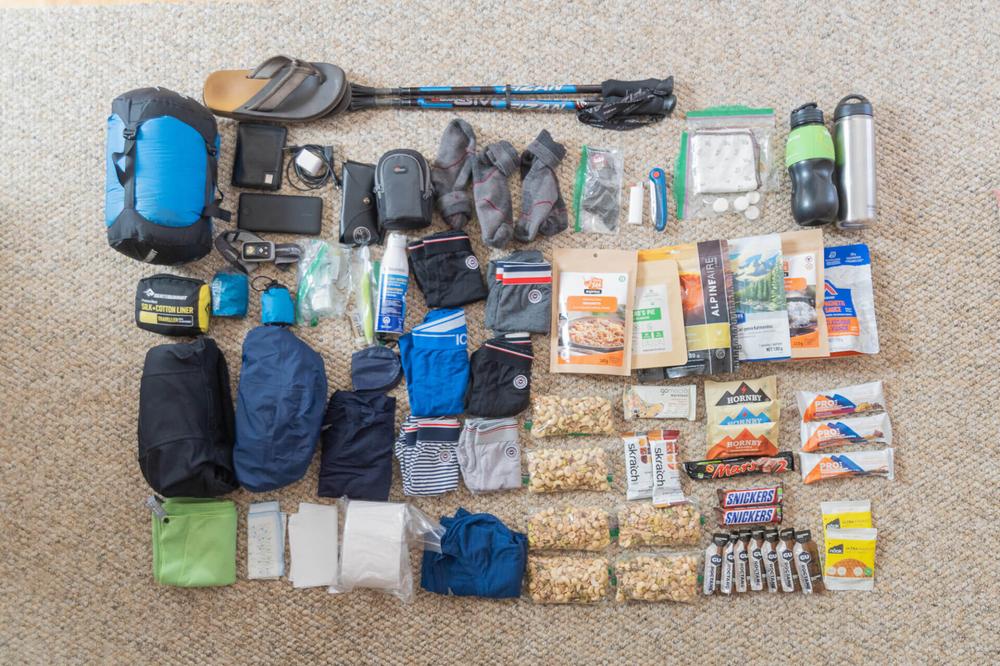 Une image montrant léquipement dun randonneur, incluant un sac à dos, des vêtements, de la nourriture et des accessoires.