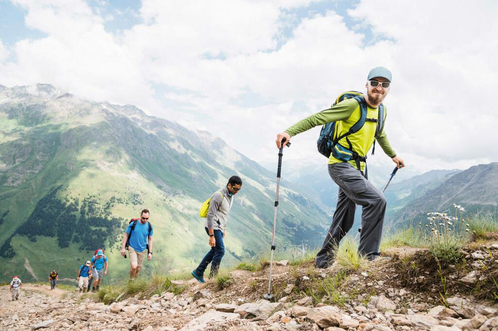 Un groupe de randonneurs gravit un sentier en montagne.