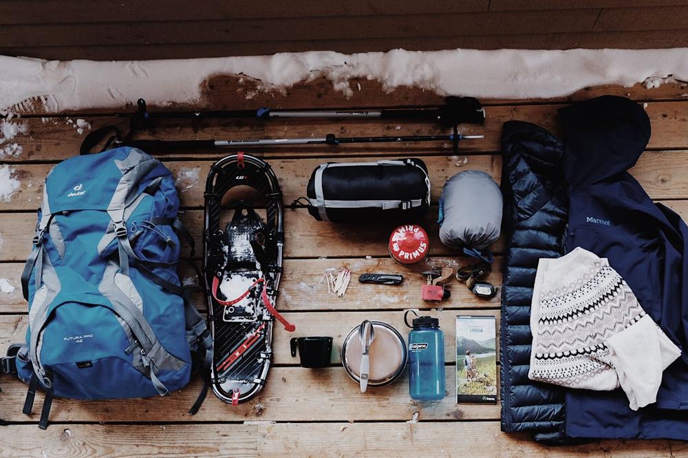 Une image montrant léquipement dun randonneur, incluant un sac à dos, des raquettes, un duvet, des vêtements chauds, et des provisions.