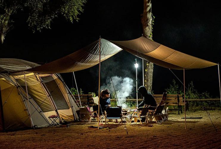 Deux campeurs sont assis autour dun feu de camp la nuit.