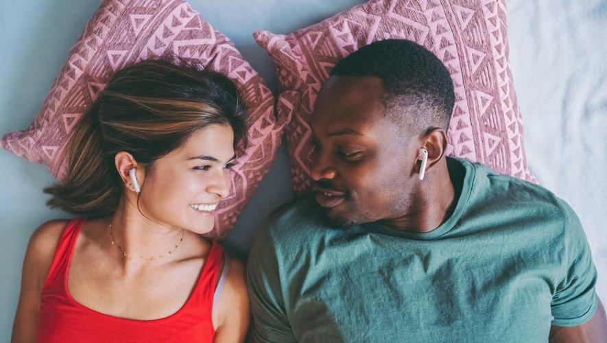 Un homme et une femme sont allongés sur un lit et se sourient.