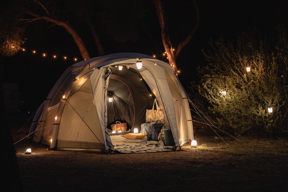 Une tente de camping éclairée la nuit.