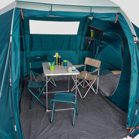 Une tente de camping spacieuse et confortable avec une table, des chaises et un lit.