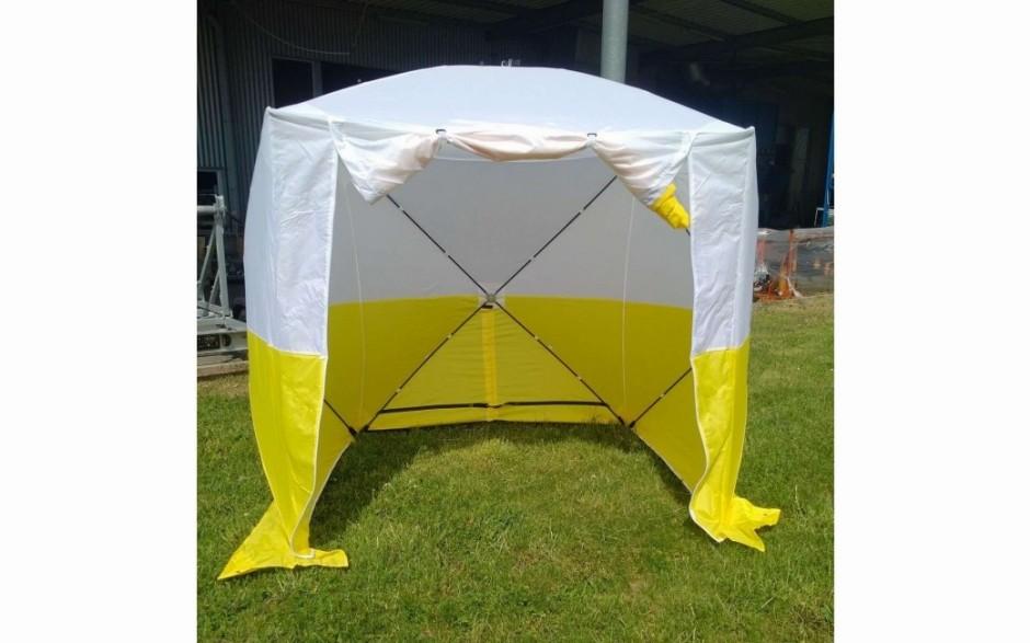 Une tente médicale de couleur jaune et blanche.