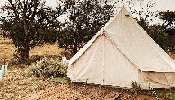 Une tente de luxe est installée dans un champ.